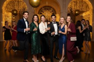 Grupa młodych ludzi na eleganckiej imprezie sylwestrowej z dekoracjami i szampanem w rękach